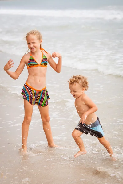 Crianças felizes brincando na praia — Fotografia de Stock
