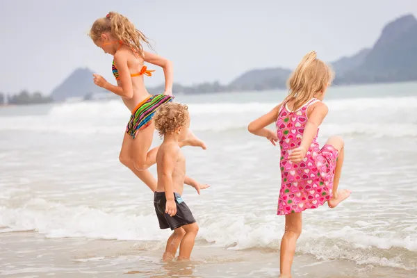 Happy kids playing on beach — Stock Photo, Image