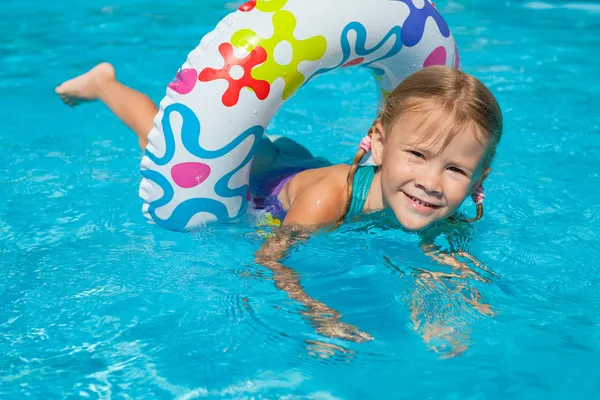 Liten flicka i poolen med gummiring — Stockfoto