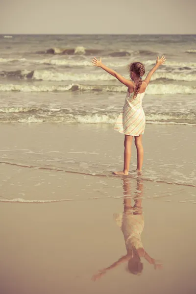 女孩站在沙滩上，看着他的影子 — 图库照片