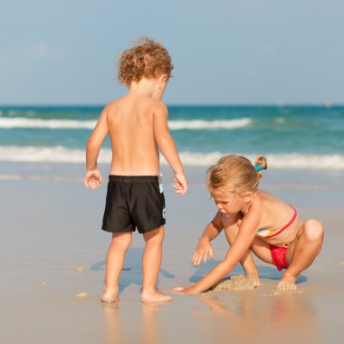 Sahilde oynayan iki mutlu çocuk.
