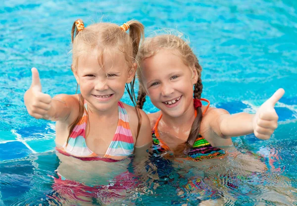 Två glada små flickor i poolen — Stockfoto