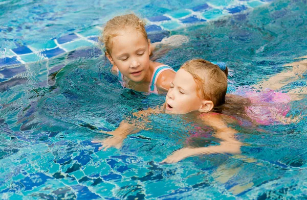 Två glada små flickor plaskade runt i poolen — Stockfoto