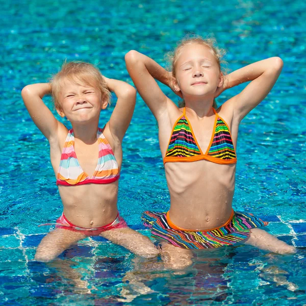 Dos niñas felices jugando en la piscina — Foto de Stock