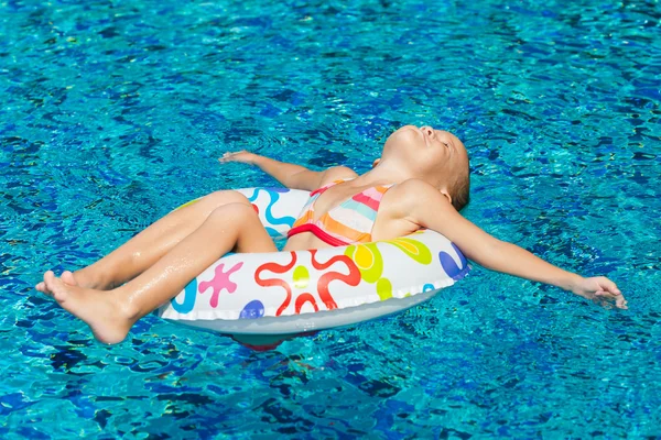 Liten flicka i poolen med gummiring — Stockfoto