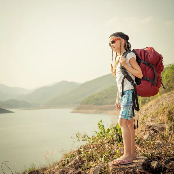 Niña con mochila tarde en la orilla del lago —  Fotos de Stock