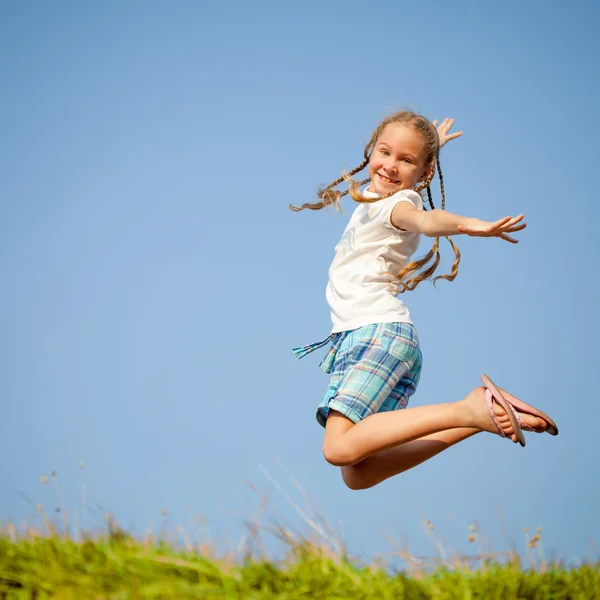 Little girl jumping over the grass — Stock Photo, Image