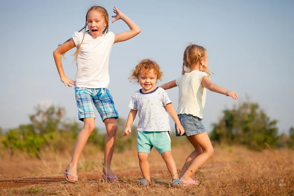 Dos niñas y un niño bailando en el camino — Foto de Stock