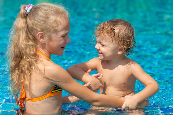 Menina e menino brincando na piscina Fotografias De Stock Royalty-Free