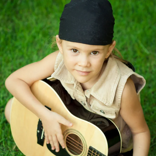 Kleines Mädchen spielt auf einer Gitarre — Stockfoto