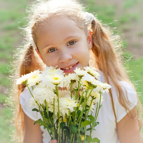 Meisje met bloemen in de hand — Stockfoto