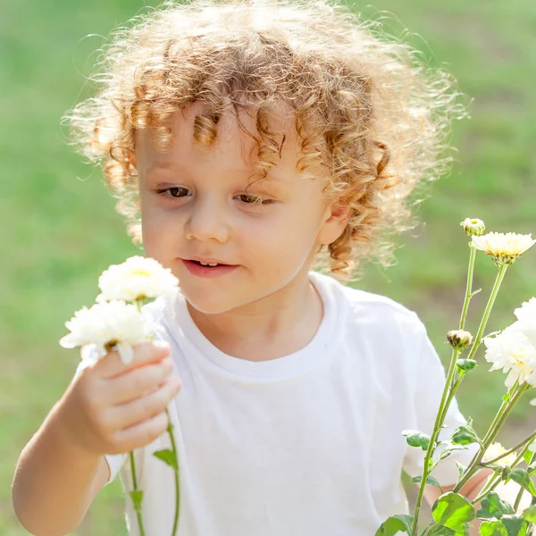 Kleine jongen met bloemen in de hand — Stockfoto