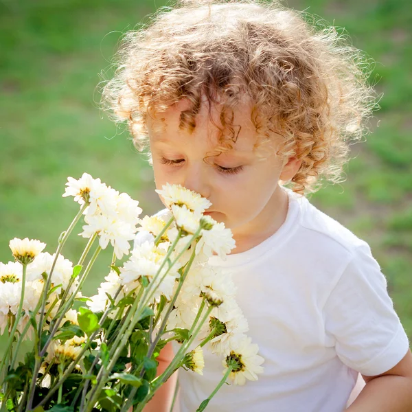 Kleine jongen met bloemen in de hand — Stockfoto