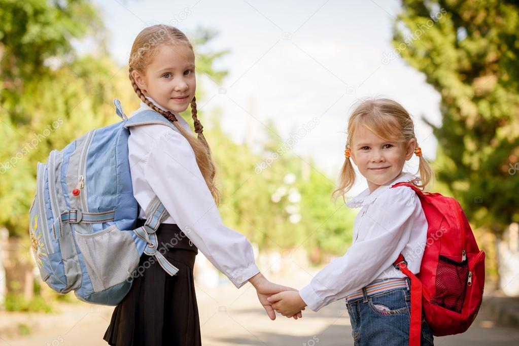 two young little girls preparing to walk to school