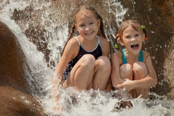 Dos niñas felices sentadas cerca de la piscina —  Fotos de Stock