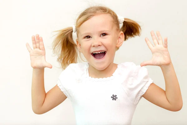 Веселая улыбающаяся маленькая девочка на белом фоне. Школьный кон — стоковое фото