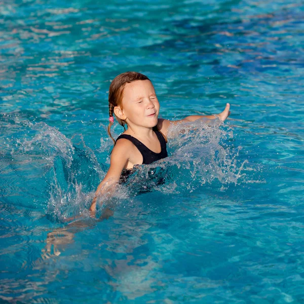 Маленькая девочка играет в бассейне — стоковое фото