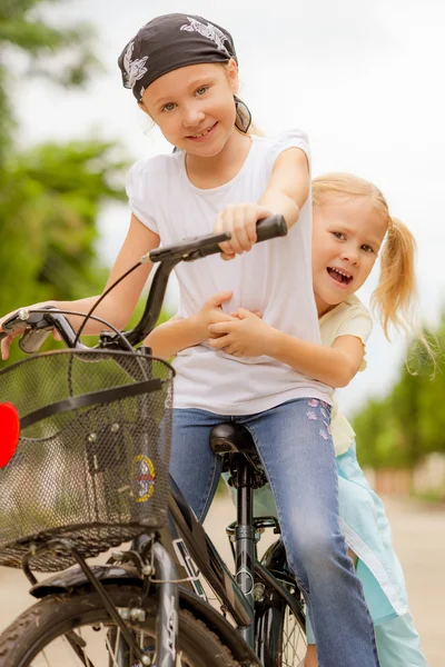 Two happy children on a bicycle — Stock Photo, Image