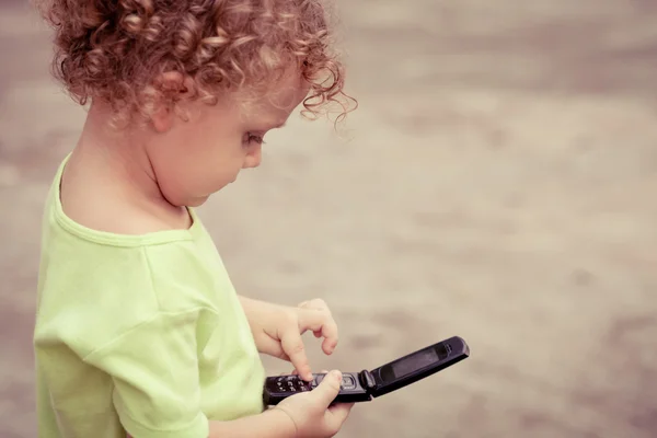 Portrait d'un petit garçon joyeux tenant un téléphone portable — Photo