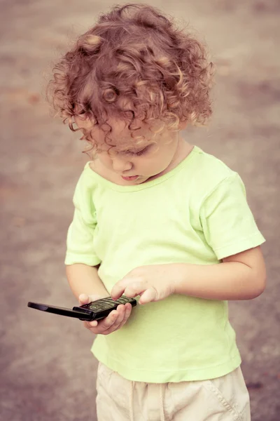 Portrait d'un petit garçon joyeux tenant un téléphone portable — Photo