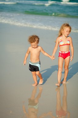 Kumsalda gün zamanında oynayan iki mutlu çocuk