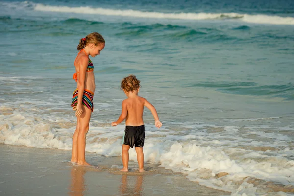 Dos niños felices jugando en la playa durante el día —  Fotos de Stock