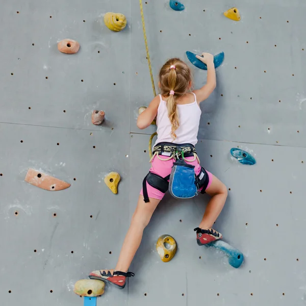 Niña escalando pared de roca — Foto de Stock