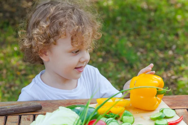 Petit garçon et légumes sur la table — Photo