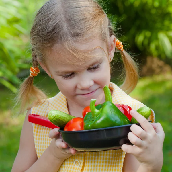 Meisje houden een pan van groenten (komkommer, paprika, tomaat, onio — Stockfoto