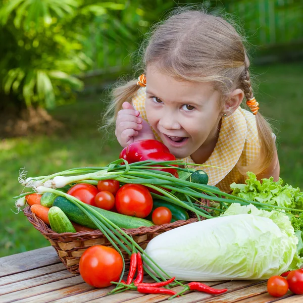 Menina segurando uma cesta de legumes (pepino, pimenta, tomate, o — Fotografia de Stock