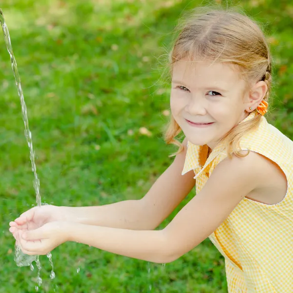 Klein meisje haar handen met water wassen — Stockfoto