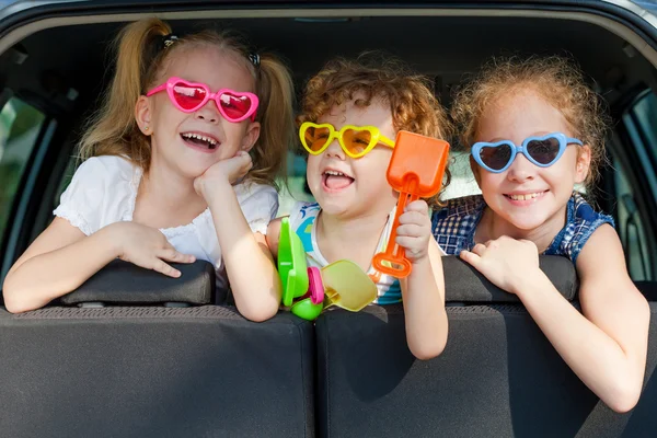 Twee kleine meisjes en jongen zittend in de auto — Stockfoto