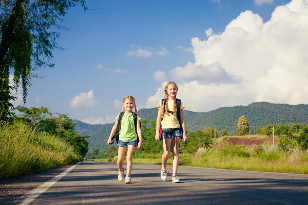 Deux filles avec des sacs à dos marchant sur la route — Photo