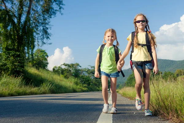 Deux filles avec des sacs à dos marchant sur la route — Photo