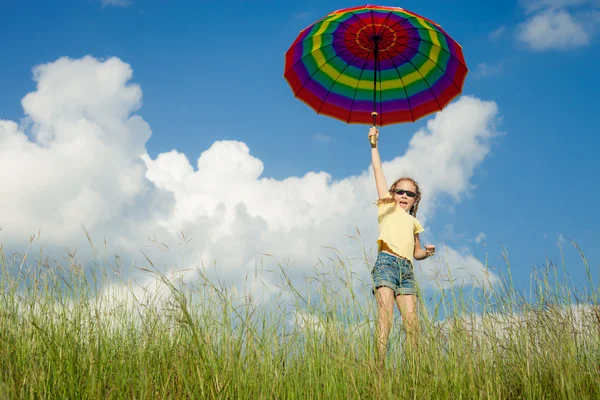 Flickan hoppar på vägen med ett paraply i handen — Stockfoto