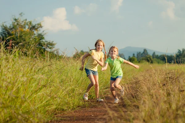 Two girls running on the road — Stock Photo, Image
