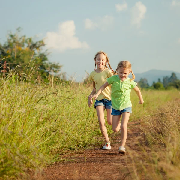 Two girls running on the road — Stock Photo, Image