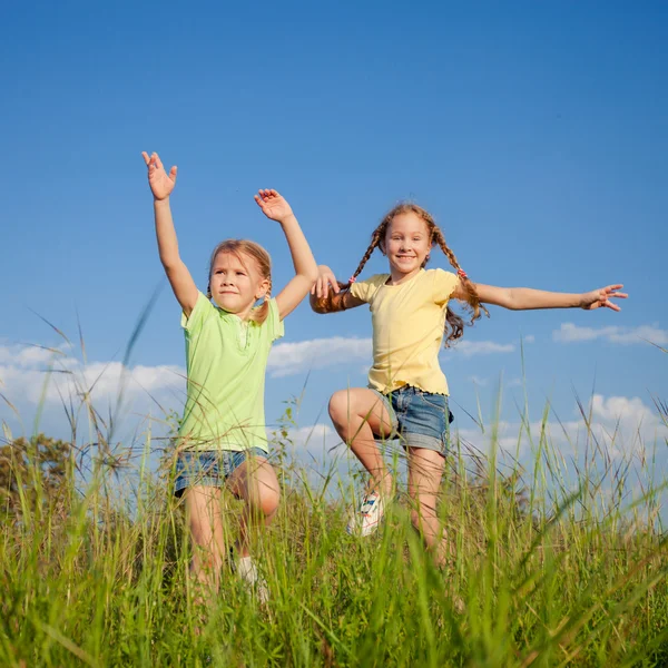 Twee meisjes springen op de weg — Stockfoto