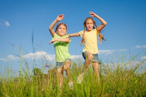 Dos chicas saltando en el camino — Foto de Stock