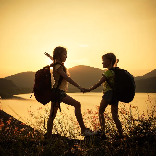 Deux petites filles regardant le coucher du soleil sur le lac — Photo