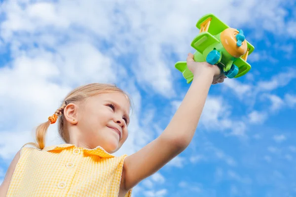 Bambina con aeroplano giocattolo in mano — Foto Stock