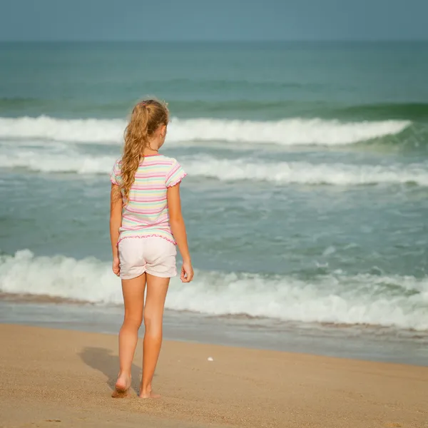 Одинокая девушка, гуляющая по пляжу — стоковое фото