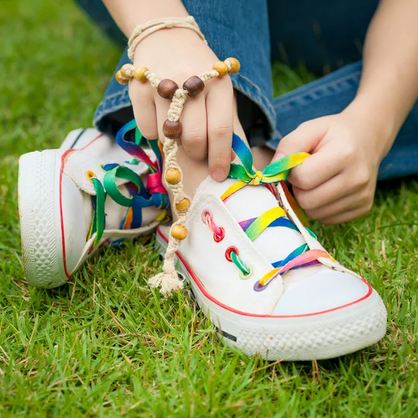 Baskets blanches sur les jambes de la fille sur l'herbe pendant l'été ensoleillé serein — Photo