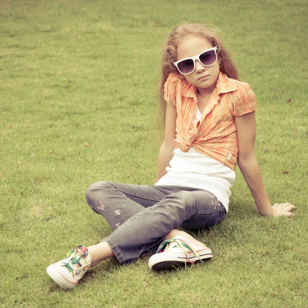 Teenager Mädchen im Park sitzt auf dem Gras. — Stockfoto