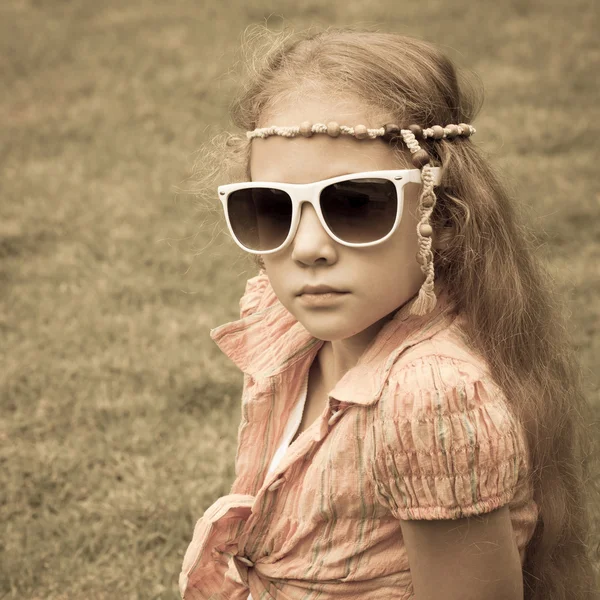 Parkta çim üzerinde oturan genç kız. — Stok fotoğraf
