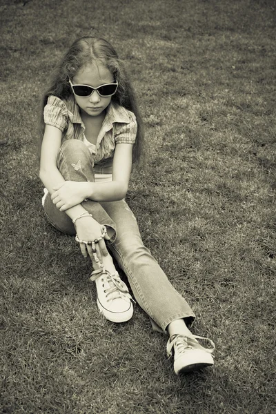 Menina adolescente no parque sentado na grama . — Fotografia de Stock