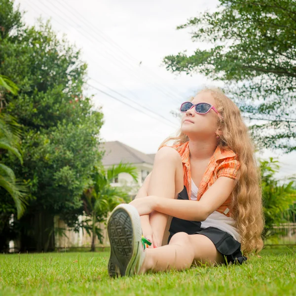 Adolescente chica en el parque sentado en la hierba . — Foto de Stock