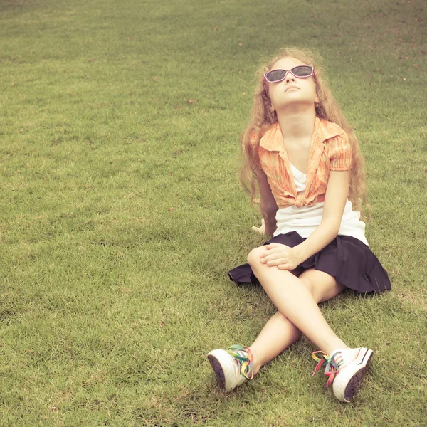 Teenager Mädchen im Park sitzt auf dem Gras. — Stockfoto