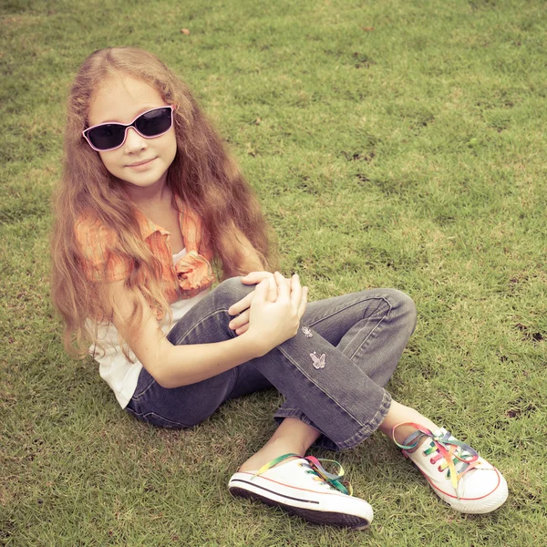 Menina adolescente no parque sentado na grama . — Fotografia de Stock