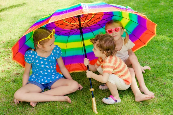 Crianças brincando na natureza com um guarda-chuva — Fotografia de Stock